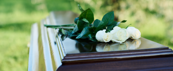 Casket with white roses laying on top