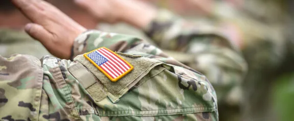 Detail shot with american flag on soldier uniform, giving the honor salute during military ceremony