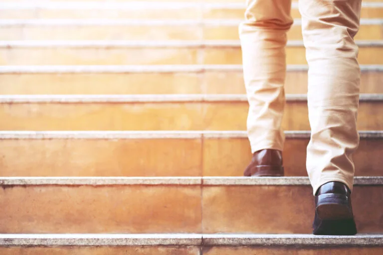 Low Section Of Man Moving Up On Steps