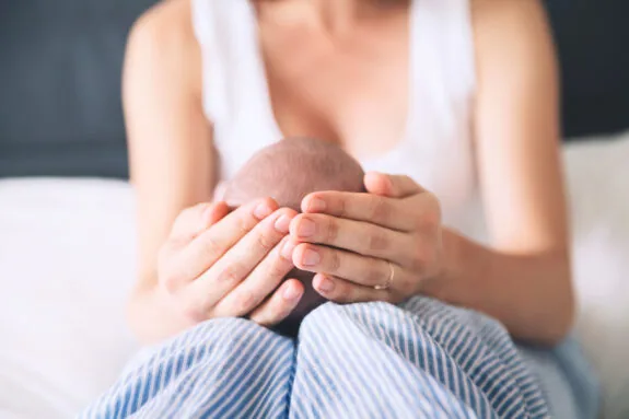 Mother and newborn baby. Baby care. Mom and child's first month of life at home. Image of happy maternity and family.